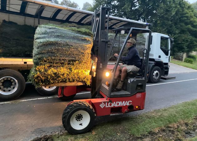 Man on forklift transporting turf.